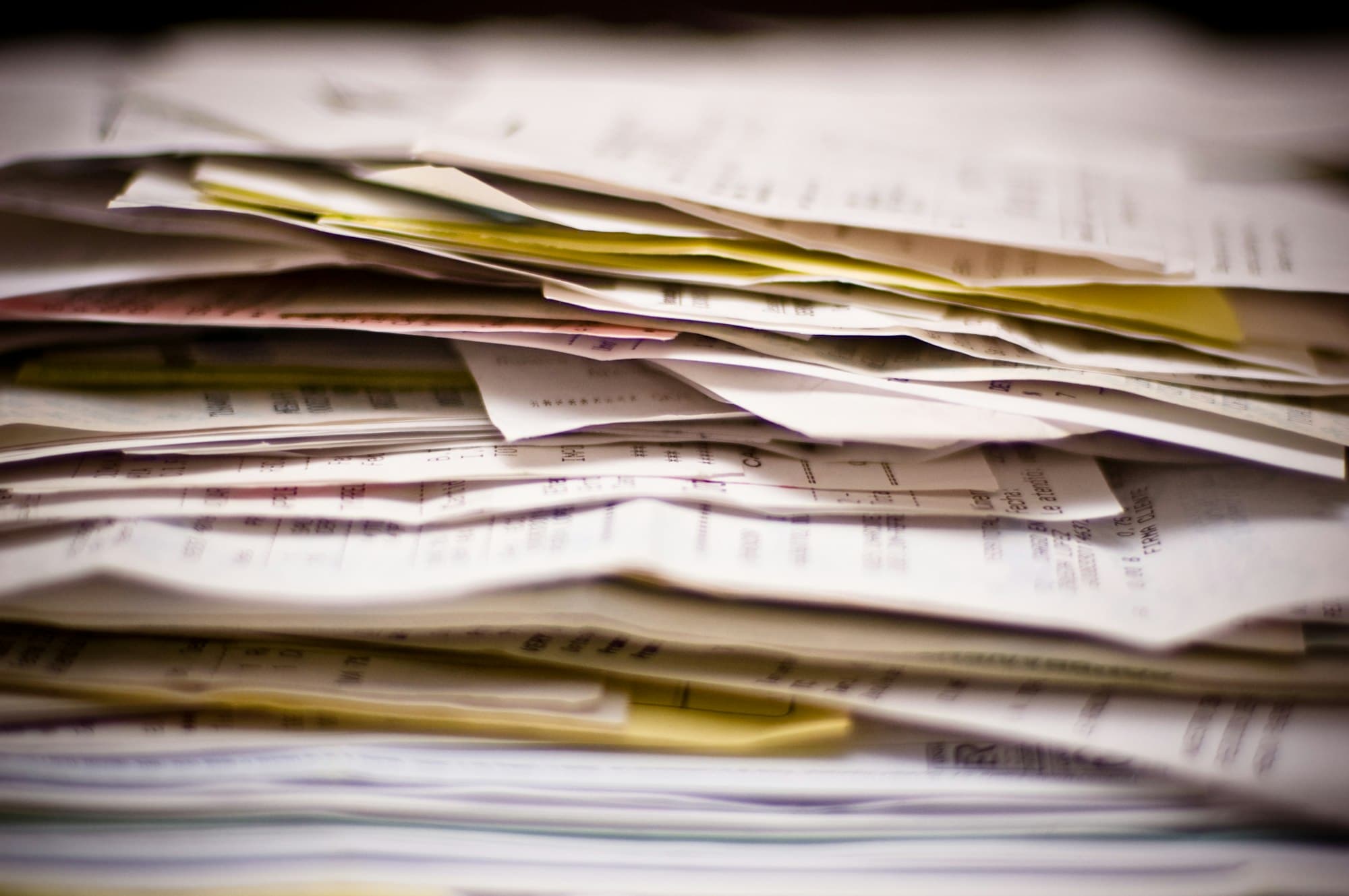 A deep stack of loose papers and forms, edges uneven.